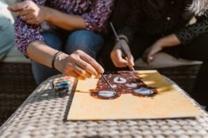 Adults enjoying a creative painting session outdoors, focusing on art and bonding.